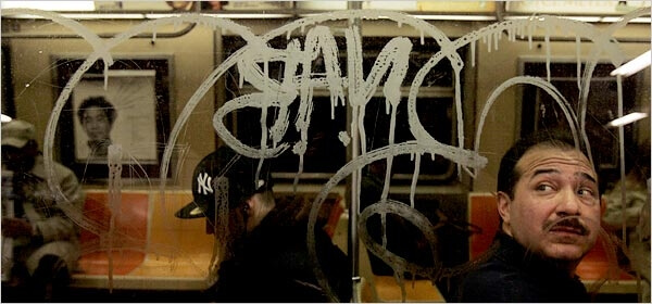 Man staring at acid etched graffiti in NYC subway window