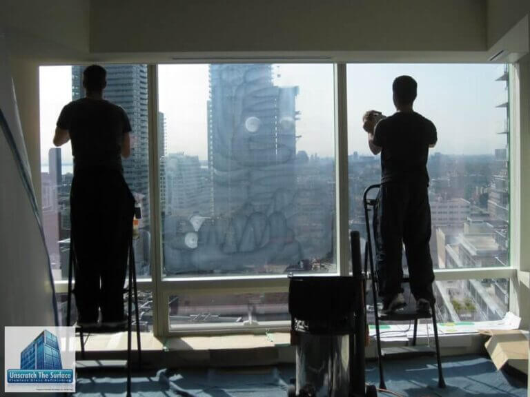 Rob and Adam performing tempered glass scratch removal at Shangri-La Toronto on step ladders