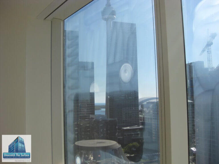 Commercial glass scratch removal Toronto - tempered glass half sanded half polished showing restoration progress